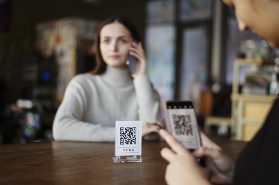 Malý stojan s QR kódom pri pokladni v kaderníctve Malý stojan s QR kódom pri pokladni v kaderníctve
